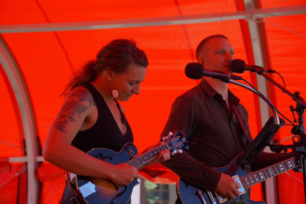 Megan and Justin of Sunny Downpour play live music in a red tent at the base of Mt Crested Butte for the Chili and Beer Festival