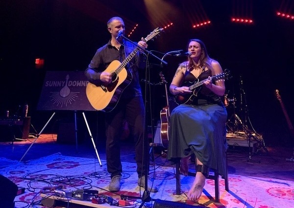 guitarists on stage, man and woman playing instrumental music